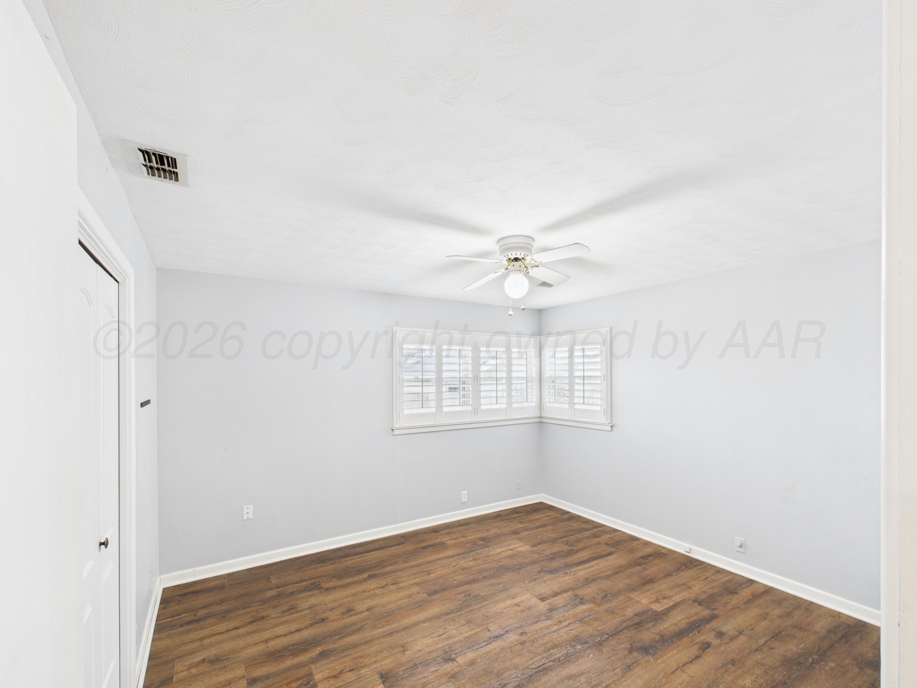 528 North Red Deer Street Pampa, TX 79065 - Photo 34 of 41 an empty room with wooden floor fan and windows