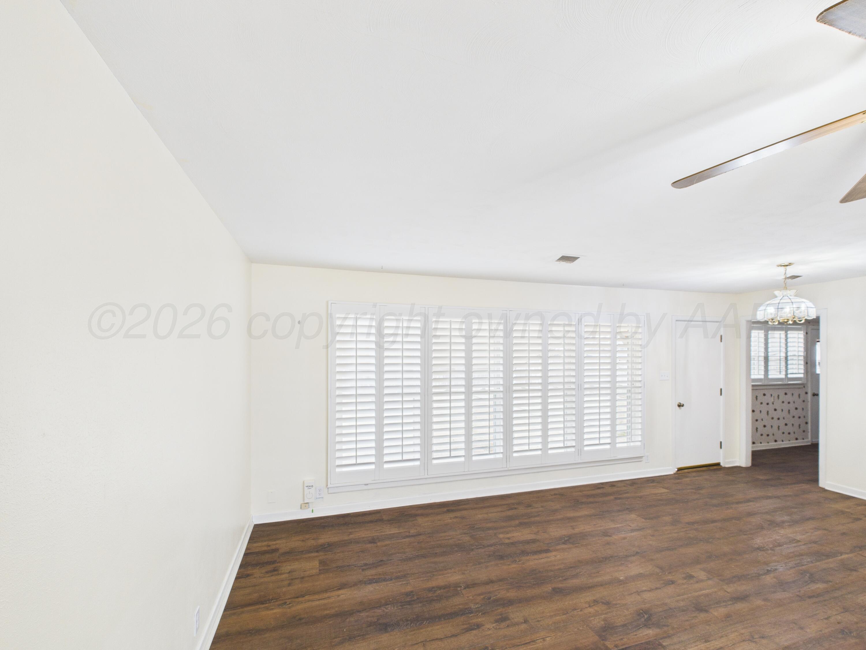 528 North Red Deer Street Pampa, TX 79065 - Photo 9 of 41 an empty room with wooden floor and windows