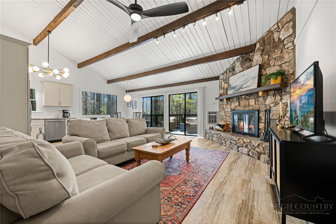 811 Pine Ridge Road Beech Mountain, NC 28604 - Photo 5 of 26 a living room with furniture a flat screen tv and a fireplace