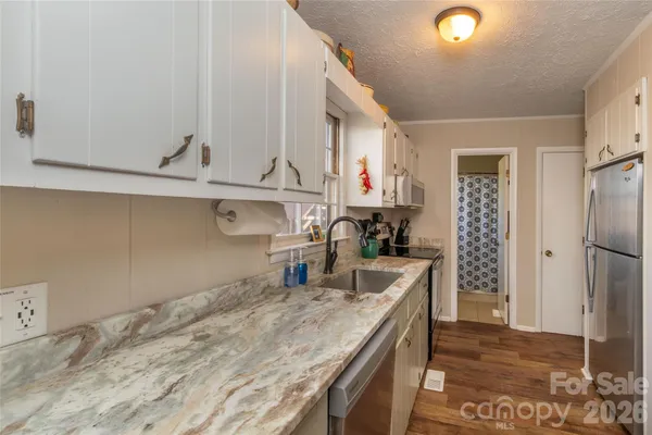 a kitchen with white cabinets and refrigerator