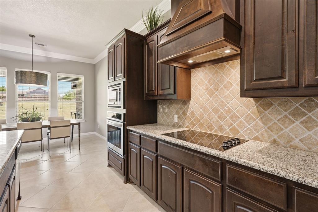 140 Heather Lane Decatur, TX 76234 - Photo 14 of 39 a kitchen with granite countertop a sink a stove and cabinets