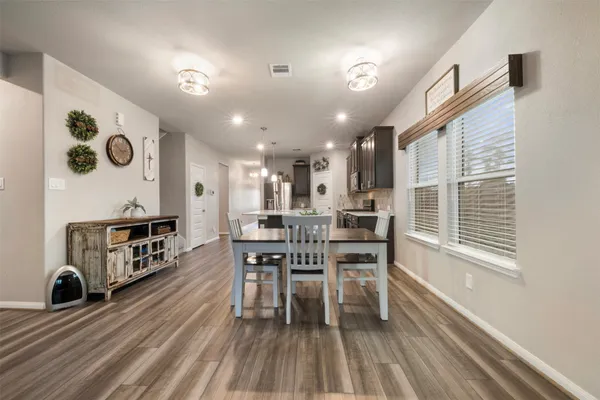 a dining room with furniture and wooden floor