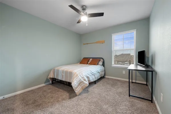 a bedroom with a bed and a computer on the desk