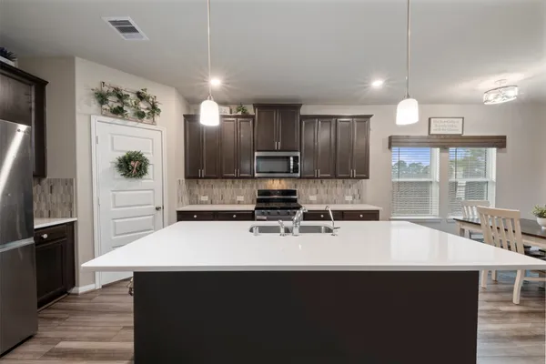 a kitchen with kitchen island a sink stainless steel appliances and cabinets