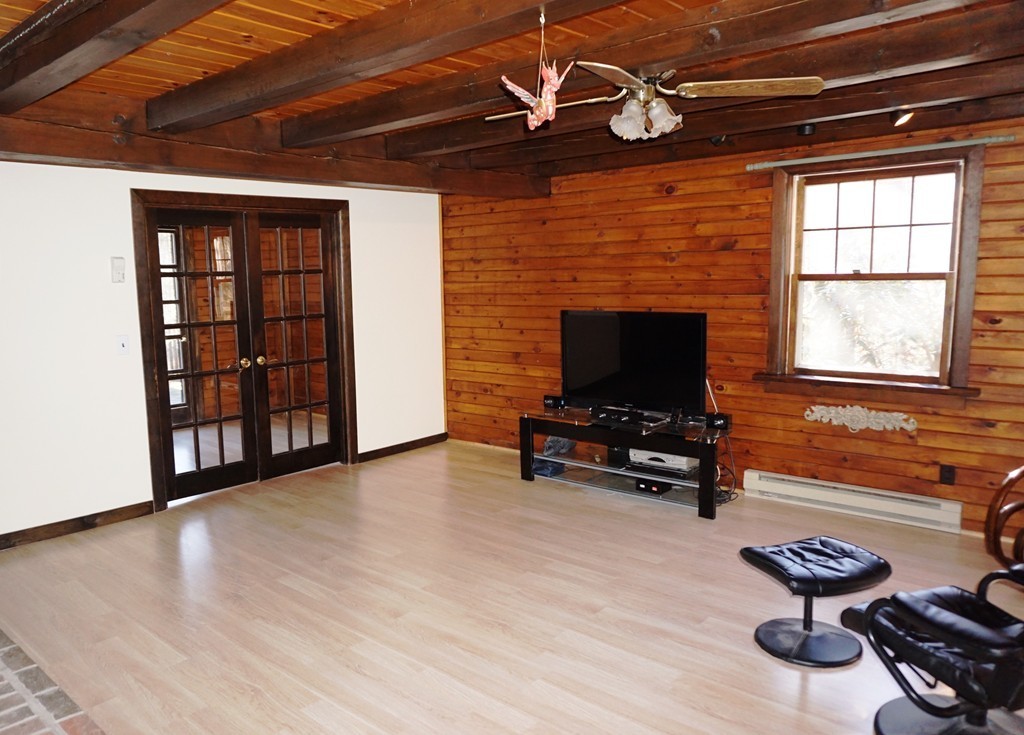 63 Breakneck Road Sturbridge, MA 01566 - Photo 7 of 30 a living room with furniture a fireplace and a flat screen tv