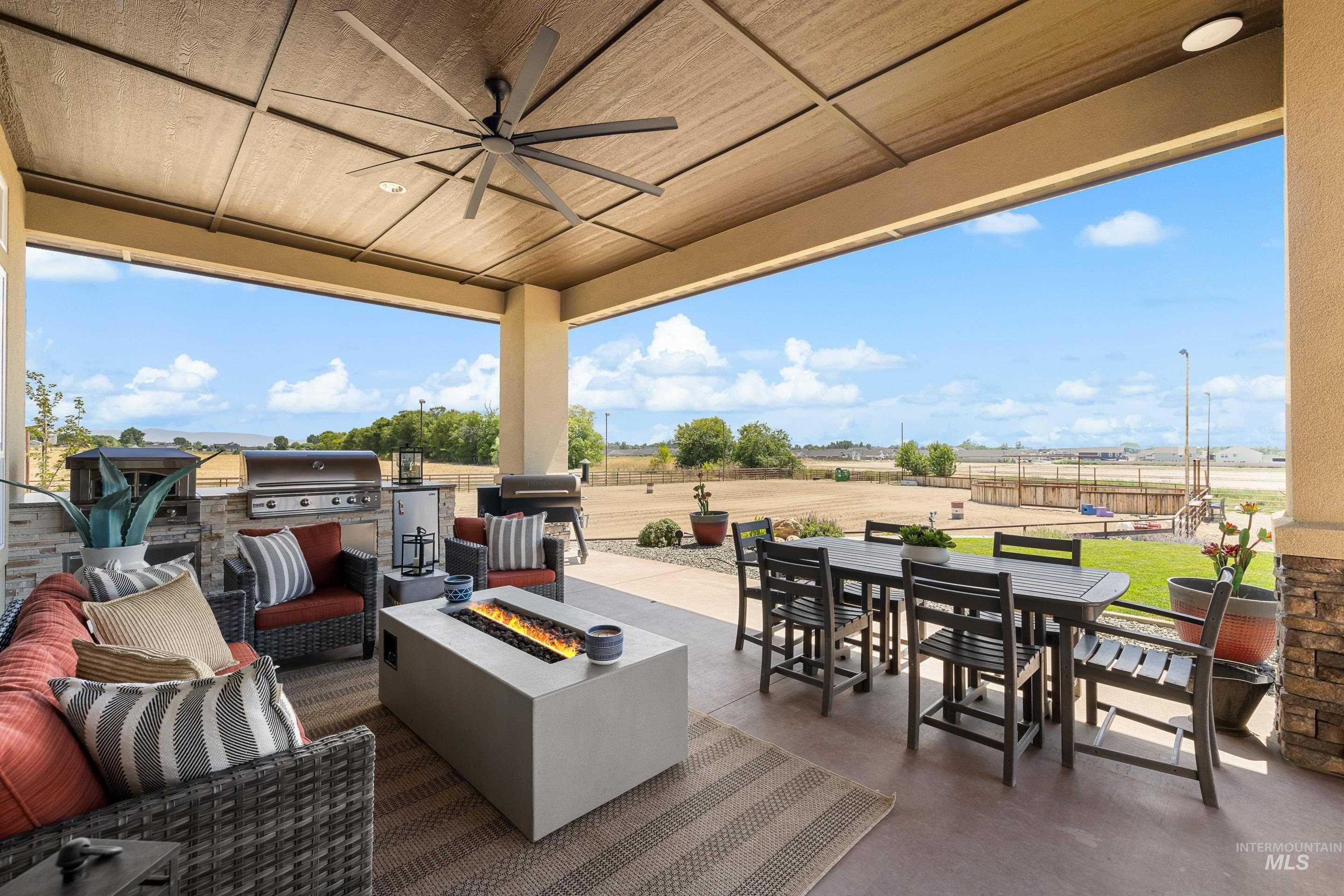 9819 Foothill Road Middleton, ID 83644 - Photo 35 of 49 View of patio / terrace featuring outdoor dining space, a ceiling fan, an outdoor kitchen, and an outdoor living space with a fire pit