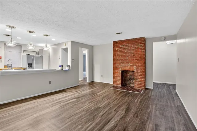a view of a kitchen with wooden floor and a fireplace