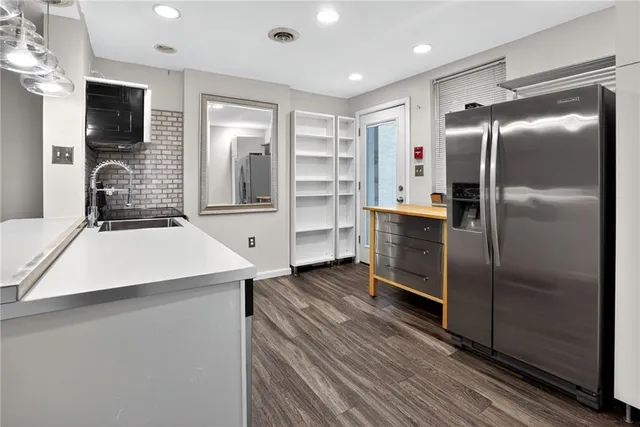 a kitchen with kitchen island a counter top space cabinets and stainless steel appliances