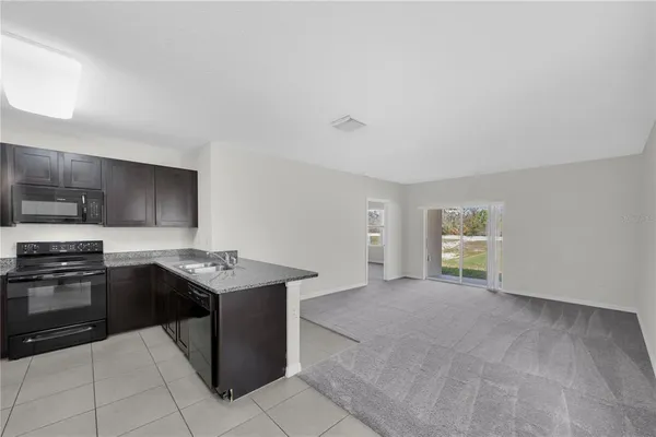 a kitchen with stainless steel appliances granite countertop a stove top oven a sink a counter space and cabinets
