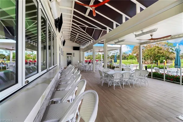 a view of a patio with a table chairs and a floor to ceiling window
