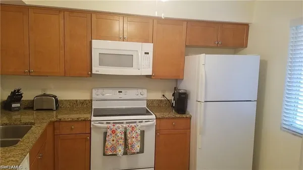 a kitchen with a refrigerator sink stove and cabinets