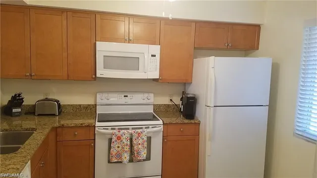 a kitchen with a refrigerator sink stove and cabinets