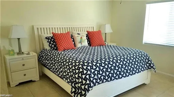 a bedroom with a bed and a night stand next to a window