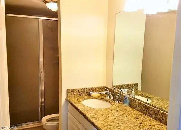 a bathroom with a granite countertop sink and a mirror