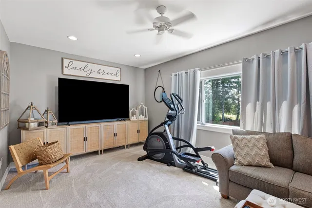 a living room with furniture a flat screen tv and a large window
