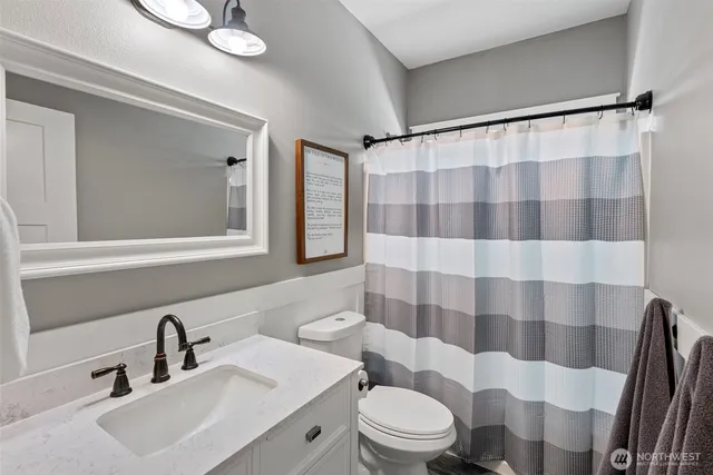 a bathroom with a sink a toilet a shower and a mirror