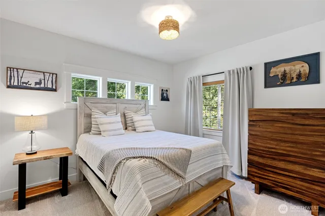 a bedroom with a bed and a lamp on dresser