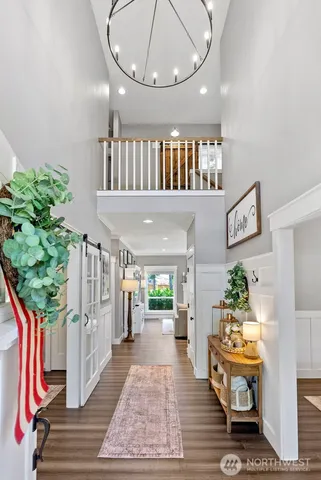 a hallway with a dining table a chandelier and a mirror