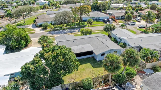 a front view of a house with a yard and tree