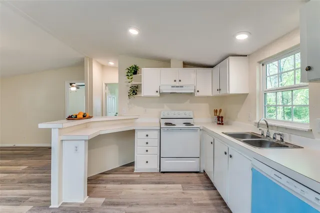 a kitchen with a white cabinets and chandelier