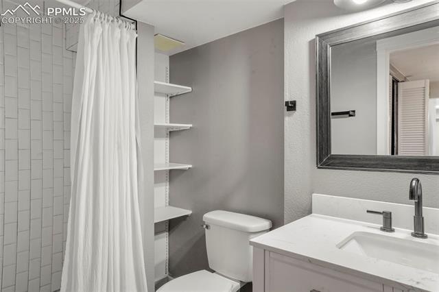 8035 Ferguson Road Peyton, CO 80831 - Photo 14 of 28 Bathroom featuring vanity, toilet, and walk in shower