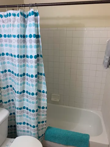 a bathroom with a toilet and a shower curtain