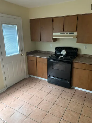 a kitchen with granite countertop a stove top oven and cabinets