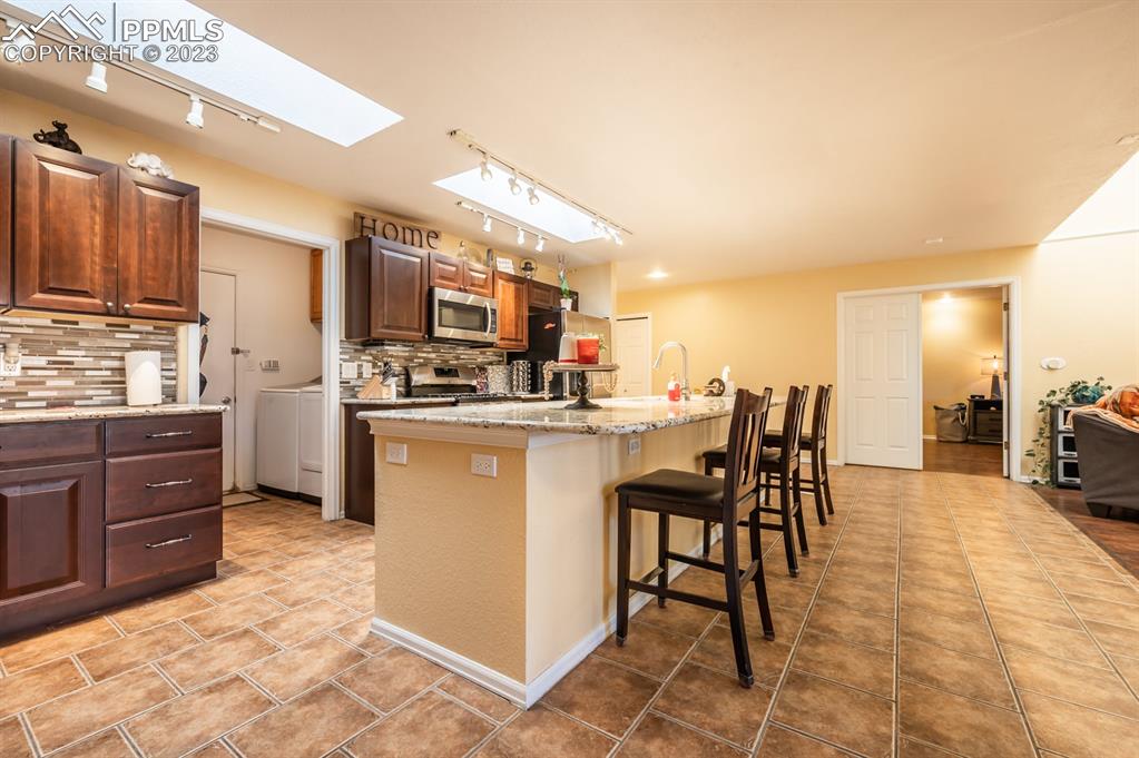 1303 Rancho Del Sol Pueblo, CO 81008 - Photo 15 of 36 a kitchen with a sink a counter top space appliances and cabinets
