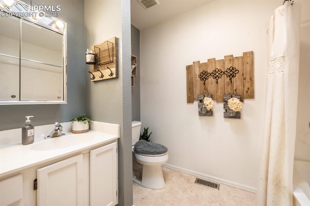 1303 Rancho Del Sol Pueblo, CO 81008 - Photo 22 of 36 a bathroom with a sink toilet and a mirror