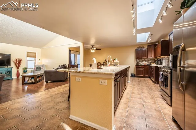 a kitchen with stainless steel appliances granite countertop a sink a stove and a refrigerator