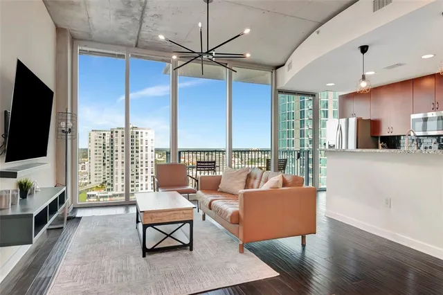 a living room with furniture a flat screen tv and a large window