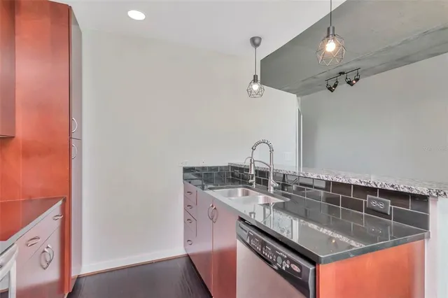 a kitchen with stainless steel appliances granite countertop a sink a stove and a refrigerator