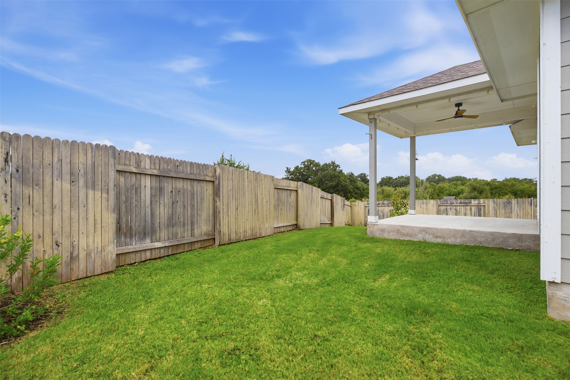 321 Gaida Loop Georgetown, TX 78628 - Photo 21 of 26 A spacious grassy yard sits enclosed by a tall wooden privacy fence.