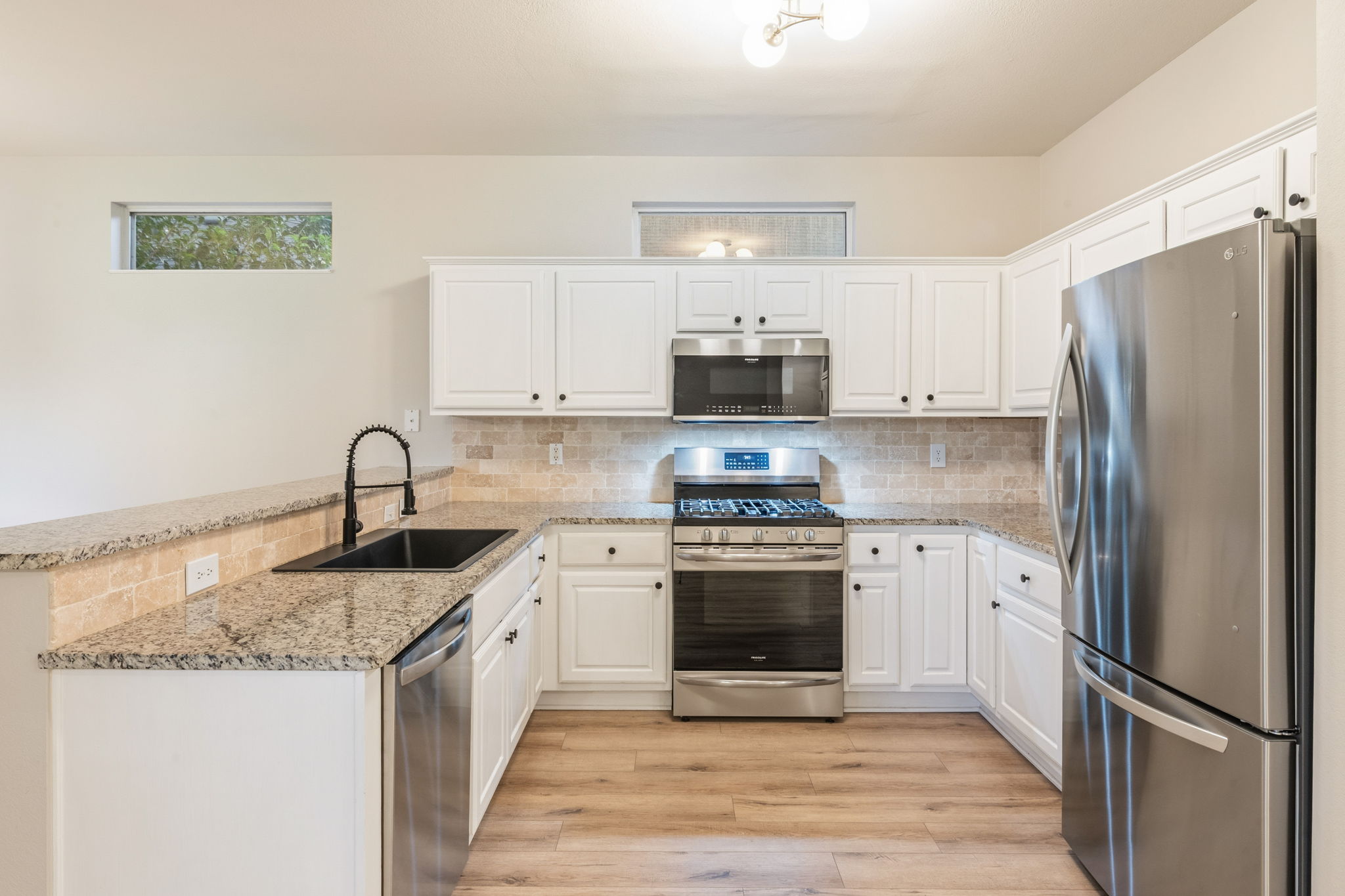 137 Trail Rider Way Georgetown, TX 78633 - Photo 5 of 29 A well-lit culinary space showcases pristine white cabinetry paired with durable granite countertops.