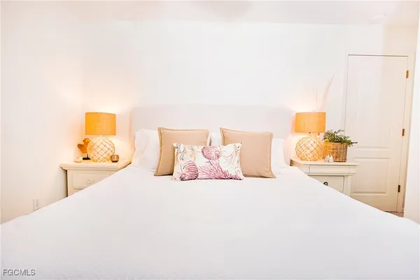 a bedroom with a bed and a lamp with potted plants