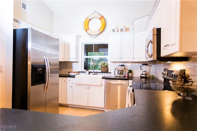 a kitchen with stainless steel appliances granite countertop a stove a sink dishwasher and a refrigerator with wooden floor