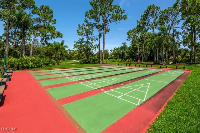 a view of a tennis ground with large trees