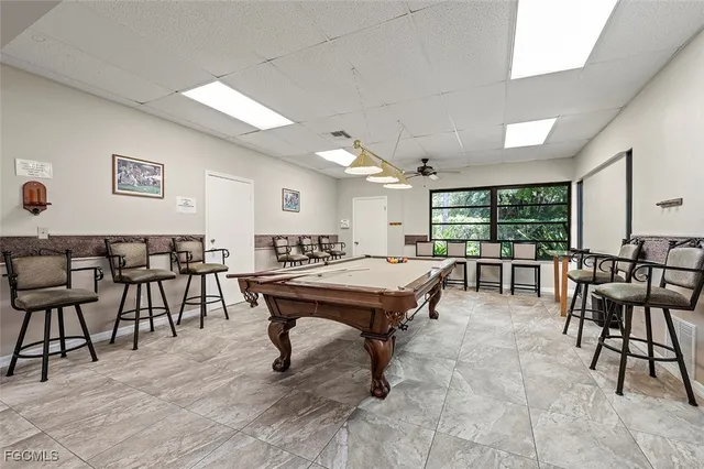 a room with lots of tables a large window and furniture