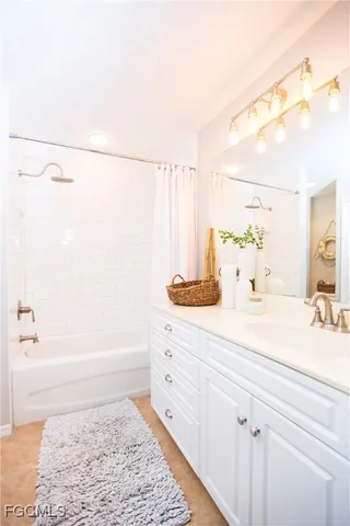 a bathroom with a tub sink and mirror