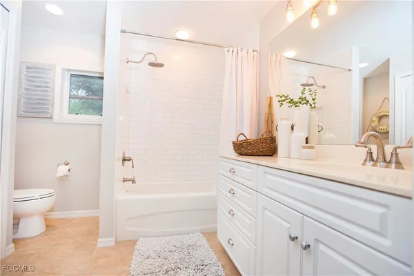 a bathroom with a bathtub shower sink vanity and toilet
