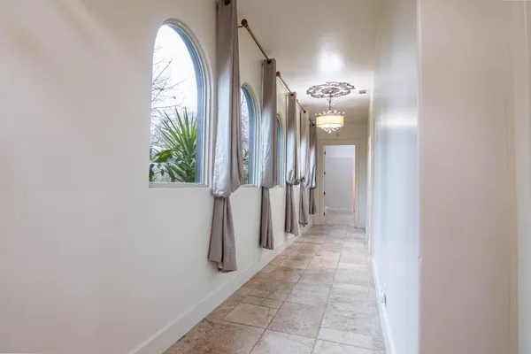 an empty room with chandelier and windows