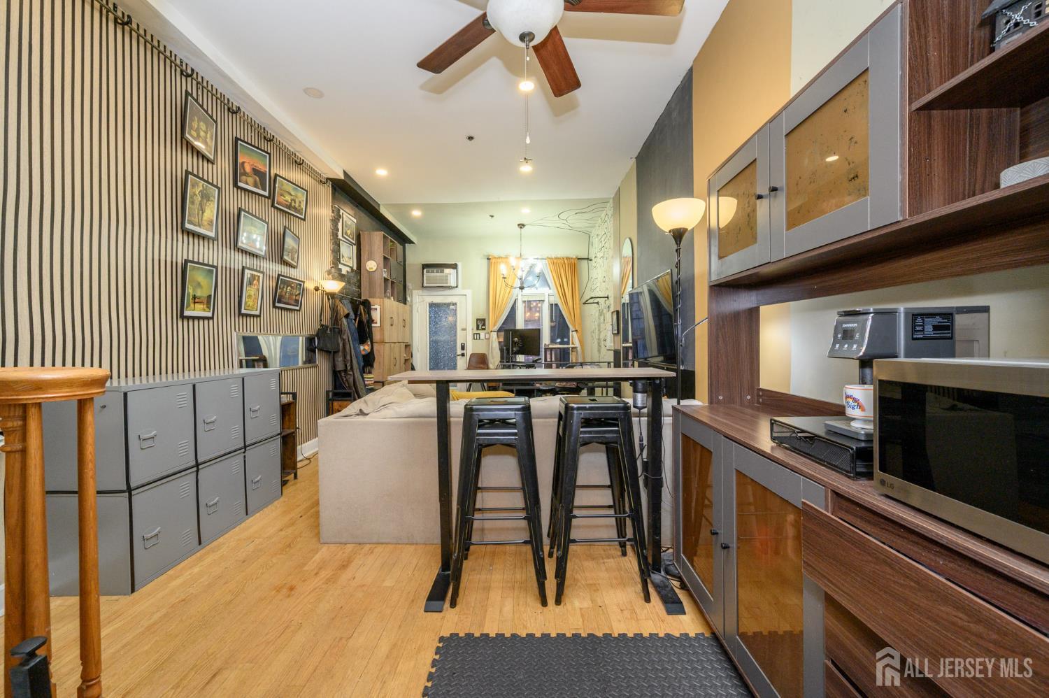 117 Clinton Street, Unit 1F Hoboken, NJ 07030 - Photo 11 of 24 a kitchen with stainless steel appliances granite countertop a stove top oven a sink a dining table and chairs with wooden floor