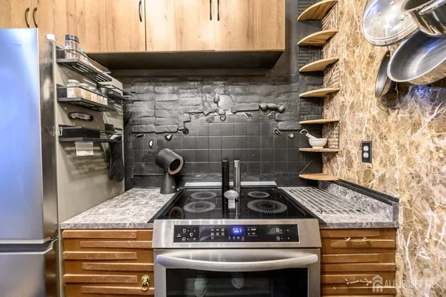 a kitchen with kitchen island granite countertop a sink a stove and cabinets