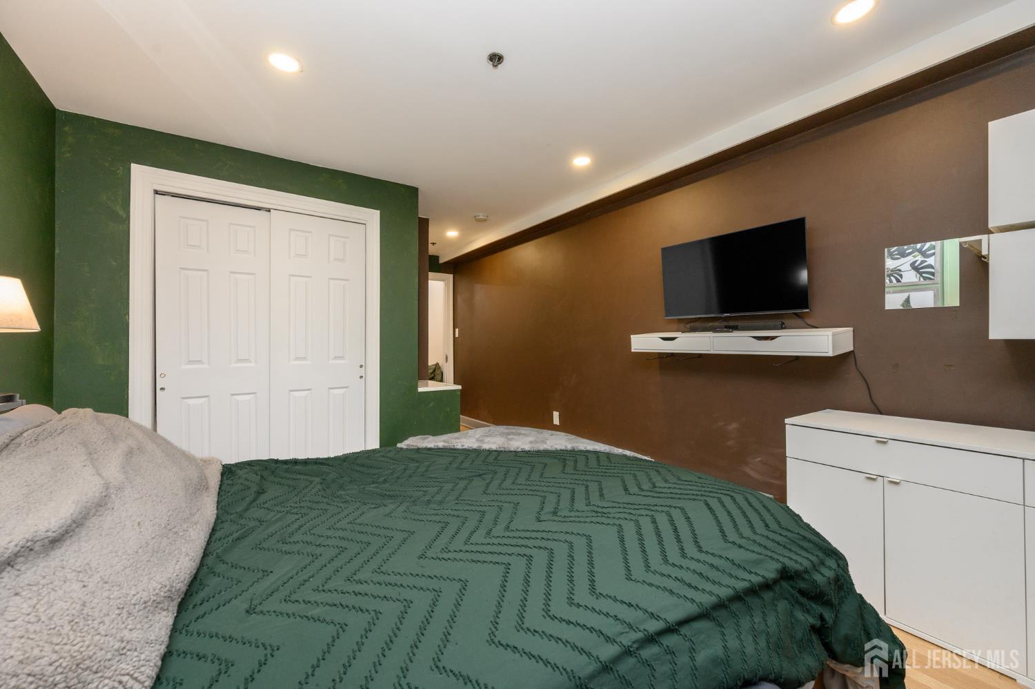 117 Clinton Street, Unit 1F Hoboken, NJ 07030 - Photo 18 of 24 a bedroom with a bed and a flat screen tv