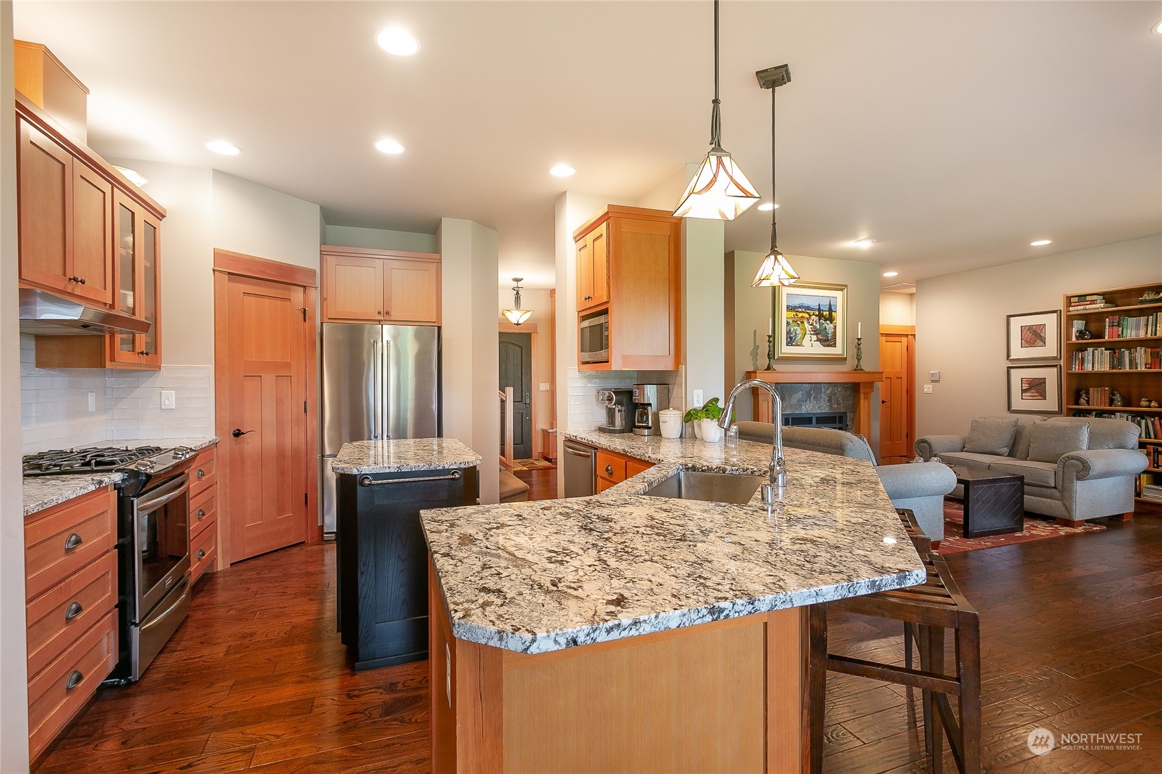 5487 Canvasback Road Blaine, WA 98230 - Photo 18 of 40 a large kitchen with kitchen island a stove a sink a counter space and living room view