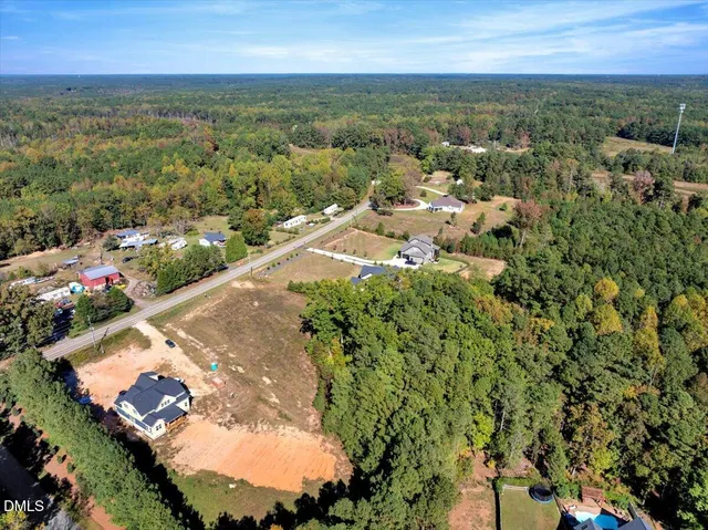 an aerial view of residential houses with outdoor space and trees