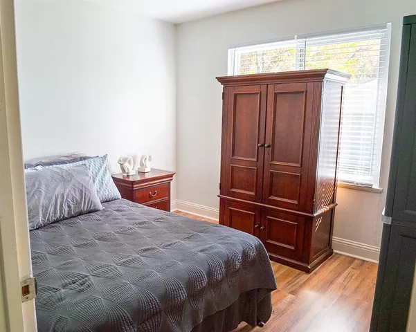 a bedroom with a bed and wooden floor