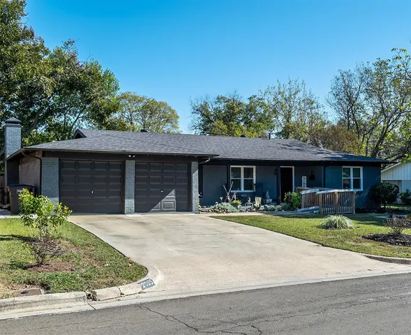 a front view of a house with a yard and potted plants
