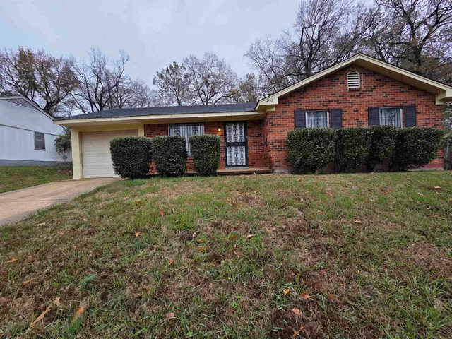 a view of a yard in front of a house with large trees