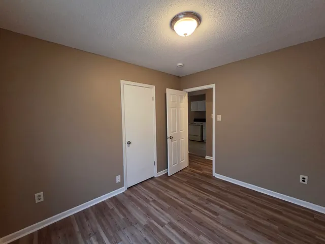 an empty room with wooden floor and closet